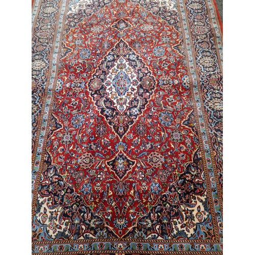 54 - Red Ground Rug with Blue central Diamond design, 228cm x 145cm