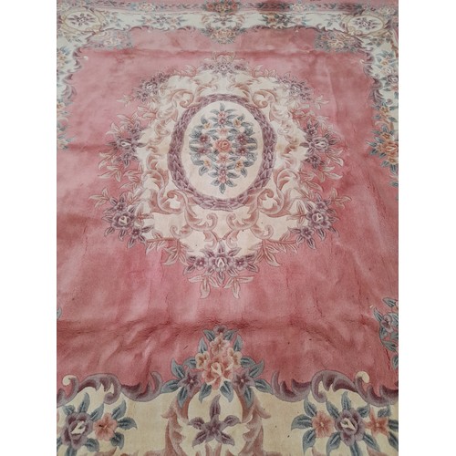 57 - Large oriental pink ground rug with central design, 300cm x 255cm