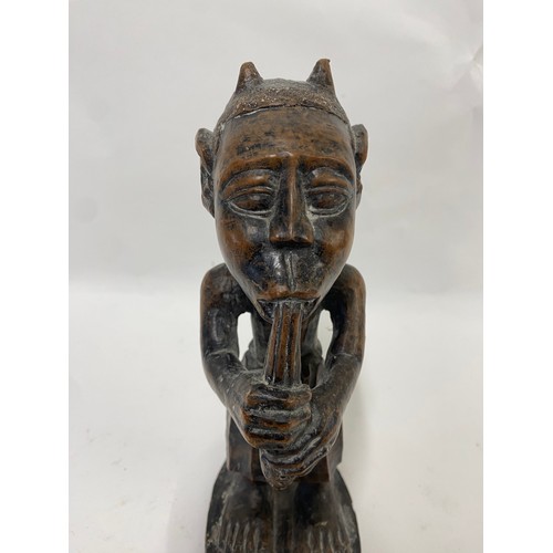 173 - Carved Wooden Tribal Figure of a Man Playing an Instrument 24cm Height