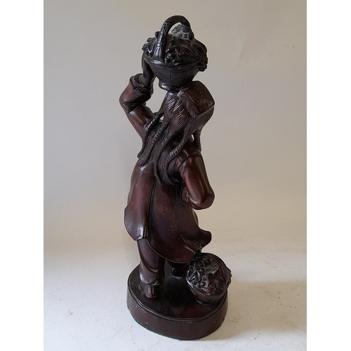 70 - Carved wood Figure of  Pig Tailed Girl carrying a basket of fruit, 31cm tall