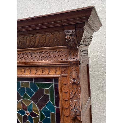 57 - Continental Two Piece Carved Wood Hunt Cupboard With Glazed Panel. 191 x 90 x 48 cms.