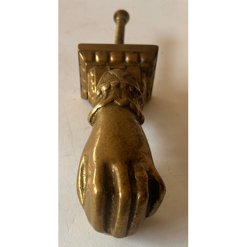 423 - Antique  Brass door knocker in the form of a hand holding a ball. 26cm x 7cm x 7cm.