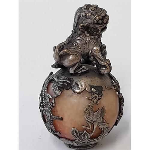 377 - A Pair of Oriental Brass Dragon stood on a ball encapsulated in an intricate metal design. 6cm high.