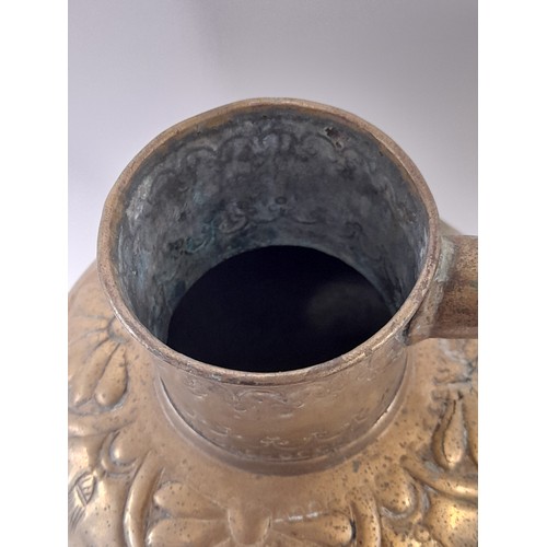 103 - Brass water Jug with lid and Repousse decoration, 38cm high x 31cm wide