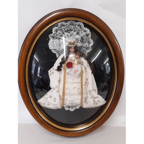 135 - Religious Wax Faced Doll in oval wood frame with plastic dome Glazing, 58cm x 48cm