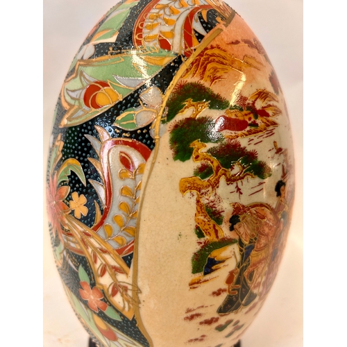 270 - Decorative Oriental Ceramic Hand painted Egg On Wooden Plinth. 24cm x 13cm.