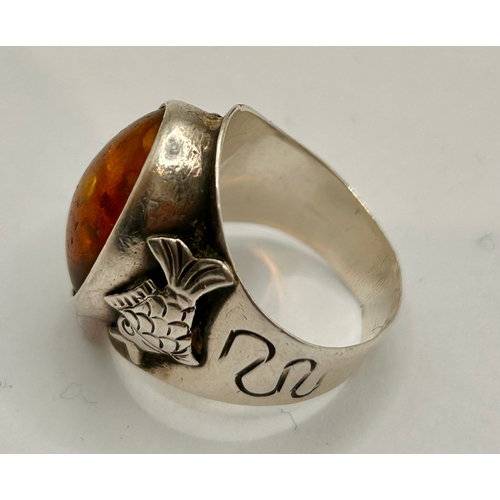 23 - Sterling Silver Decorative Ring Displaying Fishes With Raised Amber Coloured Stone. Size O, 5.94Gram... 