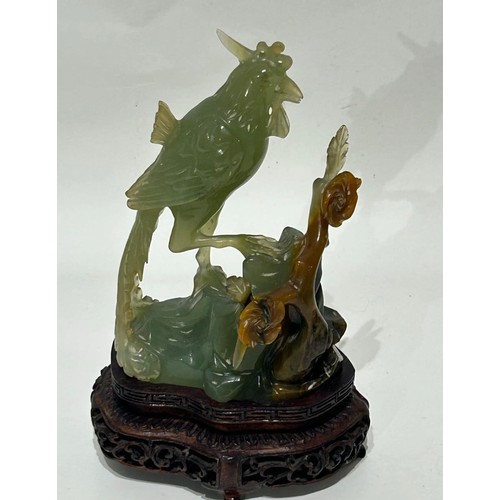 32 - Oriental jade figure of a bird and flower mounted on a carved wooden base. Measures 19cm high x 12cm