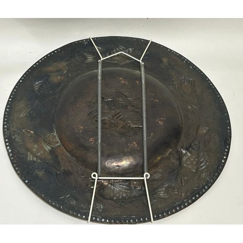 34 - Hammered copper plate in the style of arts and crafts with fish decoration. Measures 31.5 cm Diam