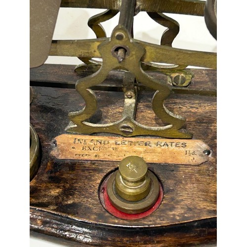 41 - Vintage Brass postal scales to include brass weights on wooden base. 10 weights in total.  Measures ... 