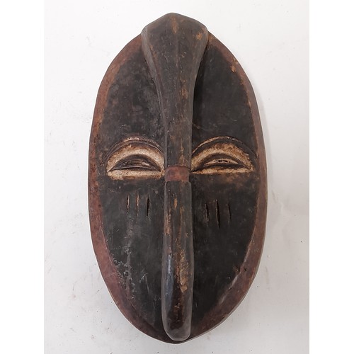 170 - Tribal Mask, Carved wood mask with handle like carved front, white eyes, 32cm x 19cm