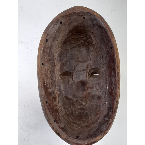 170 - Tribal Mask, Carved wood mask with handle like carved front, white eyes, 32cm x 19cm