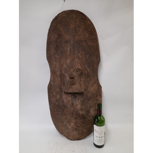 204 - Tribal Carved wood Shield with face and geometric carved design, 90cm x 40cm