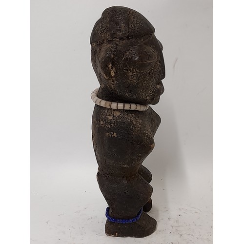 215 - Tribal Figure, Carved wood Figure with beads around neck and ankle, 26cm high