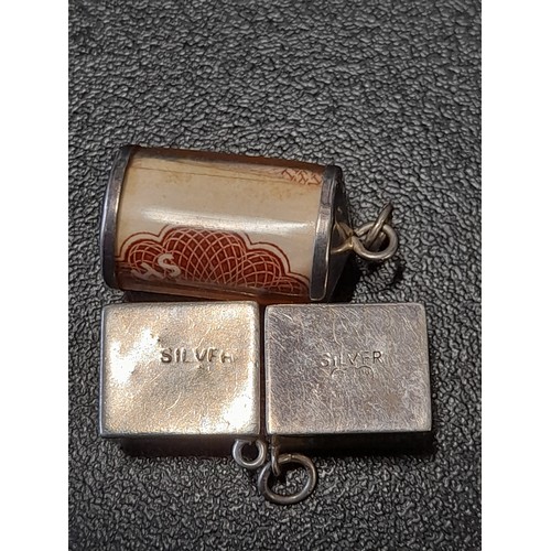 590 - 3 x Charms, 2 square charms both marked Silver and a Round charm unmarked, 2 holding a 10 shilling n... 