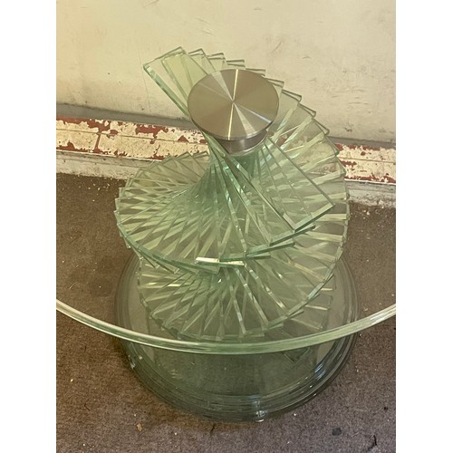 11 - A Contemporary Circular Glass Toped Low Table On A Stepped Spiral Base. 60 x 51 cms