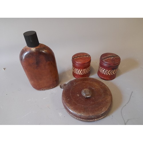 62 - 4 x Leather Clad Vintage items to include 2 cigarette tins, tape measure and a glass flask 22cm high