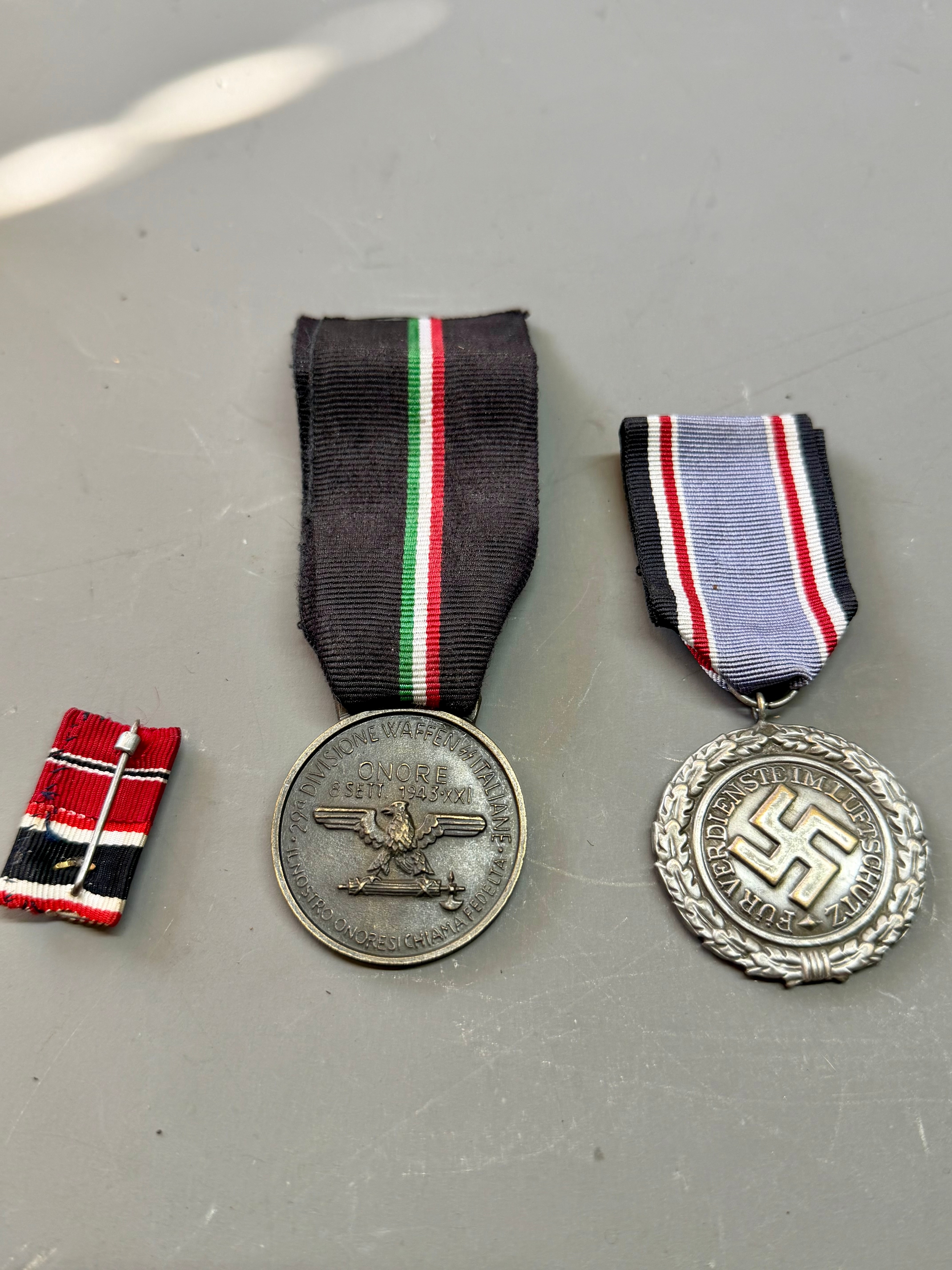 Two German Style WWII Medals Along With A Pin Badge. (3)
