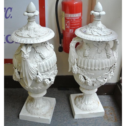 119 - Pair of ornate cast iron garden vases with ornate grapevine decoration, lids with finials, on square... 