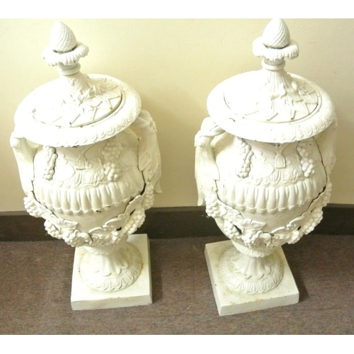 119 - Pair of ornate cast iron garden vases with ornate grapevine decoration, lids with finials, on square... 