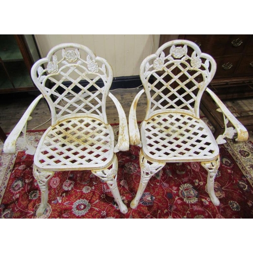 285 - Pair of cast iron garden armchairs with rose and honeycomb decoration, on shaped legs