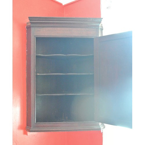 81 - Georgian oak corner wall cabinet with paneled door, serpentine fronted shelving, and copper escutche... 