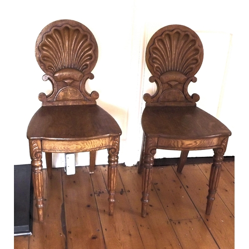 241 - Pair of Victorian oak hall chairs with shell and scroll backs, serpentine fronted seats, on reeded t... 