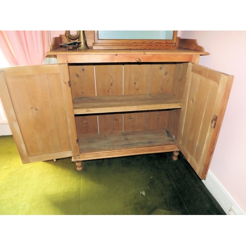 25 - Edwardian pine press with raised gallery, panelled doors with shelved interior, on turned legs