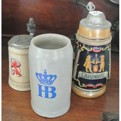 124 - Three old earthenware steins with pewter tops and shaped handles, Cardinal & Lowenbrau, and a ewer