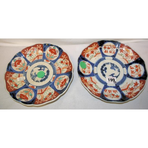 168 - Pair of circular Imari wall plaques with wavy rims, burnt ochre and deep blue foliate decorated pane... 