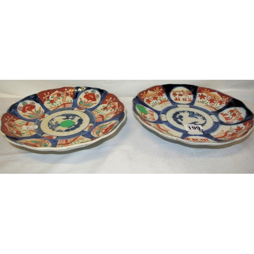 168 - Pair of circular Imari wall plaques with wavy rims, burnt ochre and deep blue foliate decorated pane... 