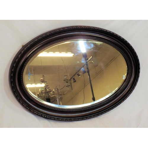 204 - Oval rosewood framed bevelled glass wall mirror with wavy border