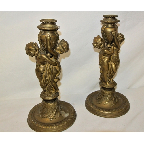 123 - Pair of ormolu candlesticks decorated with putti, on circular spreading bases