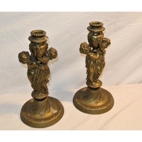 123 - Pair of ormolu candlesticks decorated with putti, on circular spreading bases