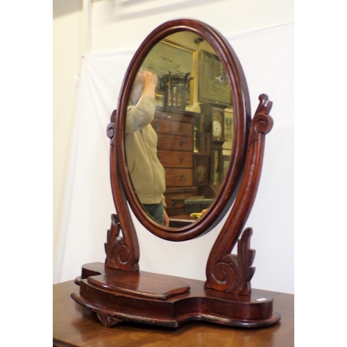 131 - Victorian mahogany framed oval swivel mirror with scroll decorated columns, on shaped base