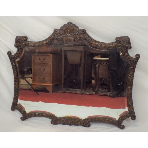 157 - Ornate shaped bevelled glass wall mirror with ornate foliate and grapevine decorated frame