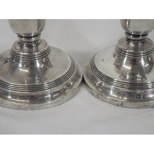 115 - Pair of Birmingham silver dwarf candlesticks with reeded rims, on spreading bases, dated 1925 Total ... 