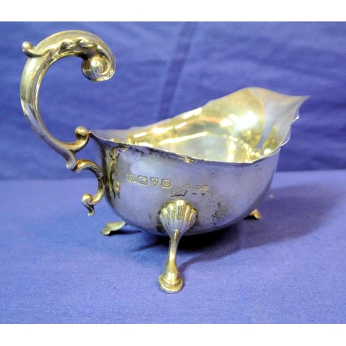 123 - Chester silver boat-shaped sauceboat with wavy rim, scroll handle, on three hoof feet with shell knu... 