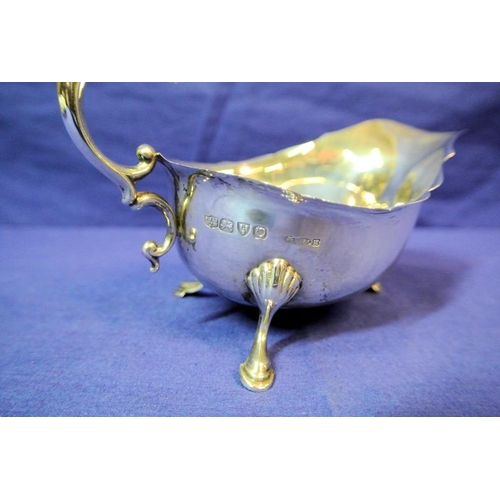 123 - Chester silver boat-shaped sauceboat with wavy rim, scroll handle, on three hoof feet with shell knu... 