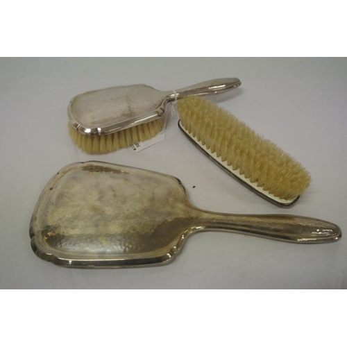 4 - Three piece Continental silver dressing set -bevelled hand mirror and two brushes.