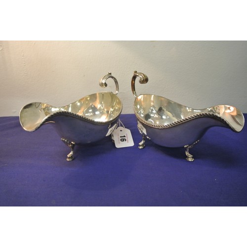 16 - Pair of heavy silver plated sauceboats with gadroon rims and leaf capped scroll handles, each on thr... 