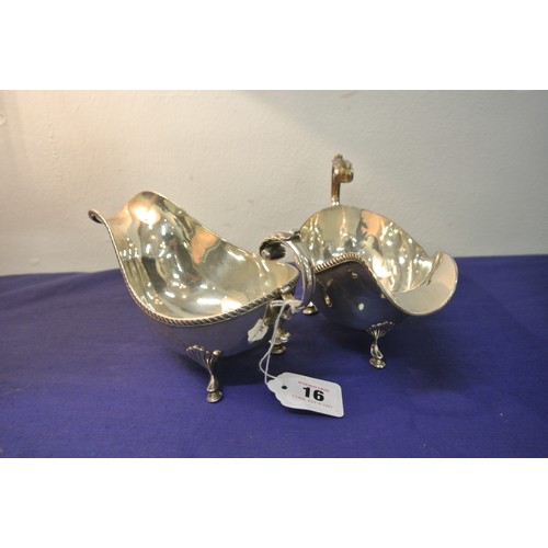 16 - Pair of heavy silver plated sauceboats with gadroon rims and leaf capped scroll handles, each on thr... 