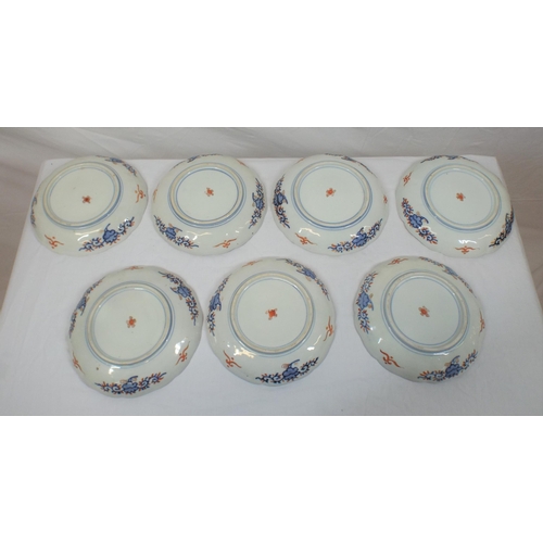 102 - Set of seven Imari plates with wavy rims, burnt ochre and deep blue and yellow foliate decoration