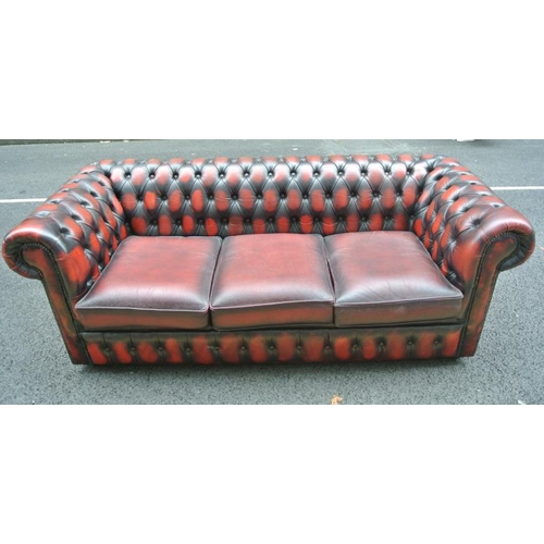 271 - Leather upholstered three seater Chesterfield couch with buttoned upholstery, on castors