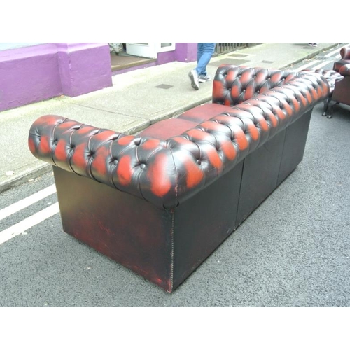 271 - Leather upholstered three seater Chesterfield couch with buttoned upholstery, on castors