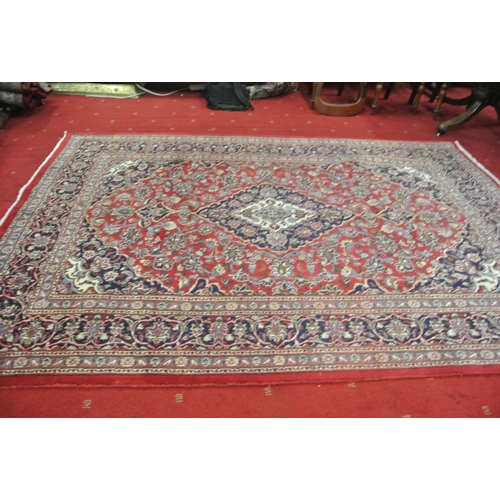 134 - Full pile red ground Persian Kashan carpet with floral medallion design 290x200cm