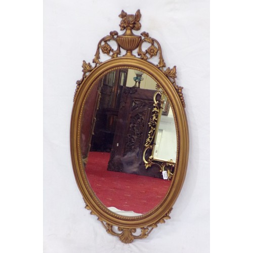 262 - Regency design oval wall mirror with ornate foliate and urn decoration