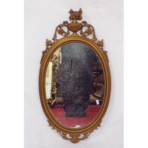 262 - Regency design oval wall mirror with ornate foliate and urn decoration