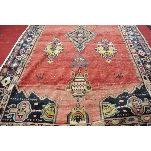 49 - Washed red ground hand woven Persian village rug with unique patterns