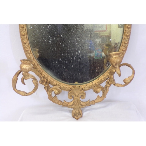 223 - Victorian gilt framed oval wall mirror with foliate decoration and sconces